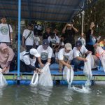 Peserta menebarkan benih ikan lokal ke Kali Surabaya dari atas perahu